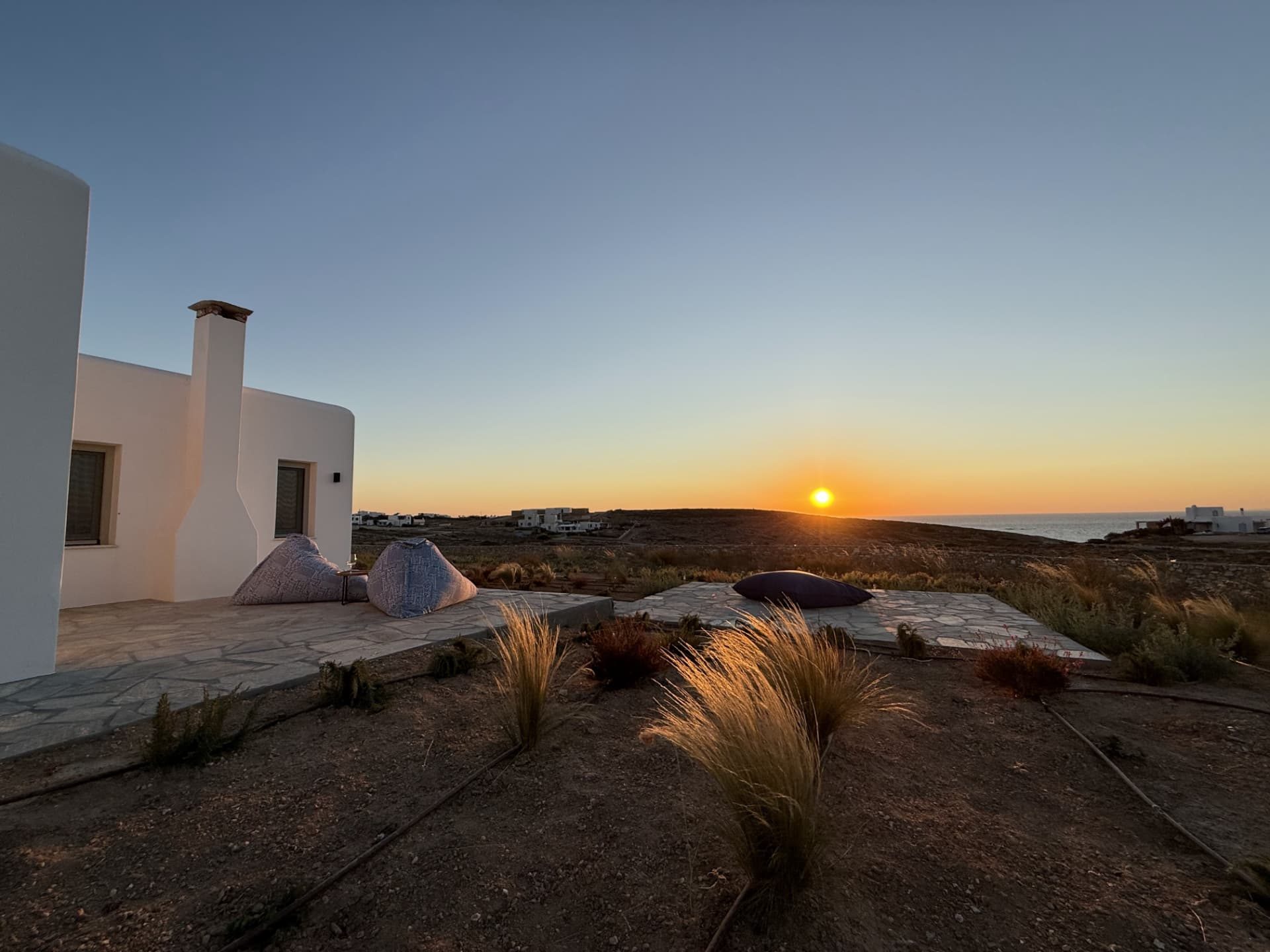 The sun setting over the gulf of Parikia, seen from the stone terrace at DEON